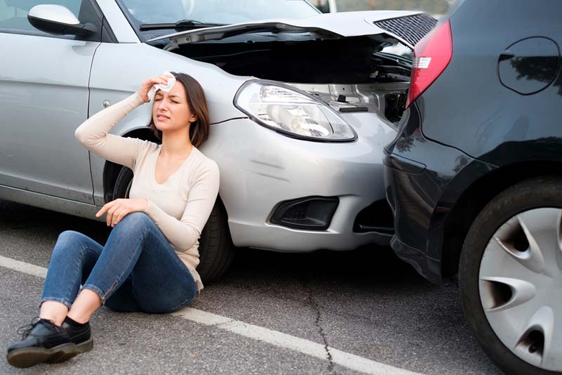 Woman holding her head after a car collision