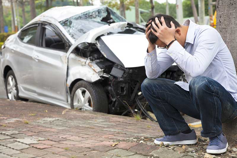 man with a wrecked silver car