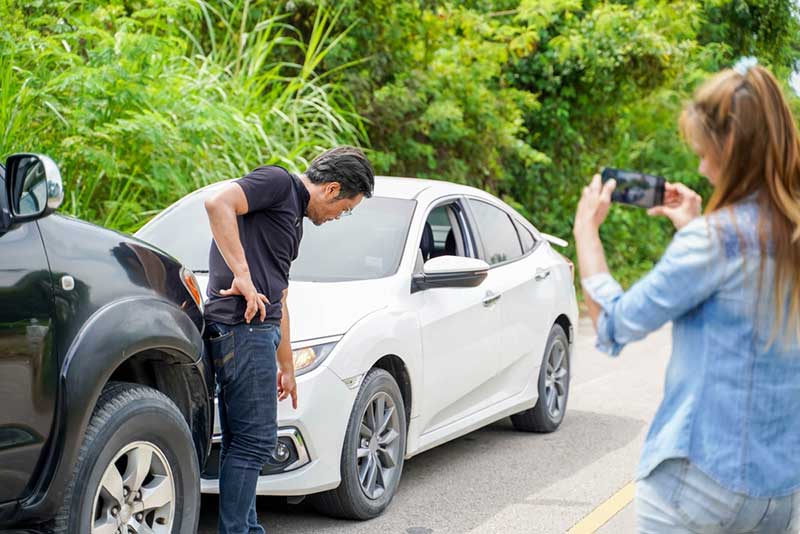 woman taking picture of a car accident