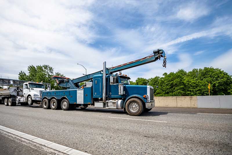 blue tow truck towing big rig